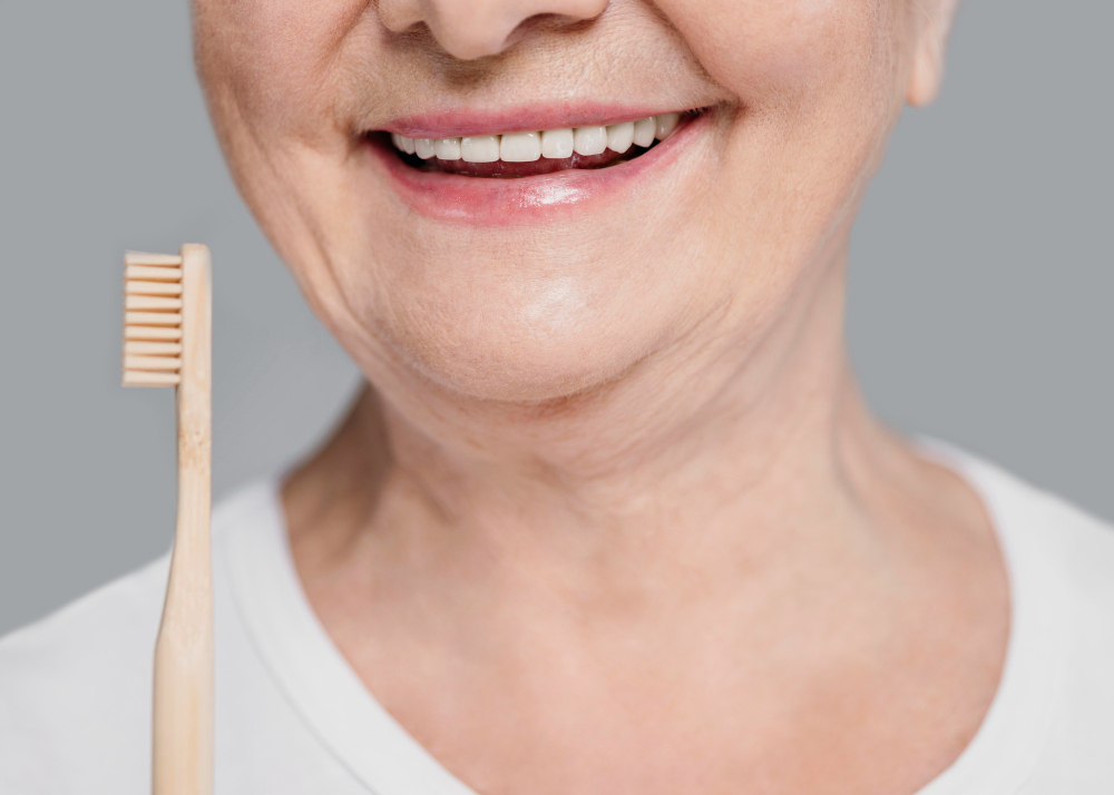 Femme âgée souriante avec une brosse à dents